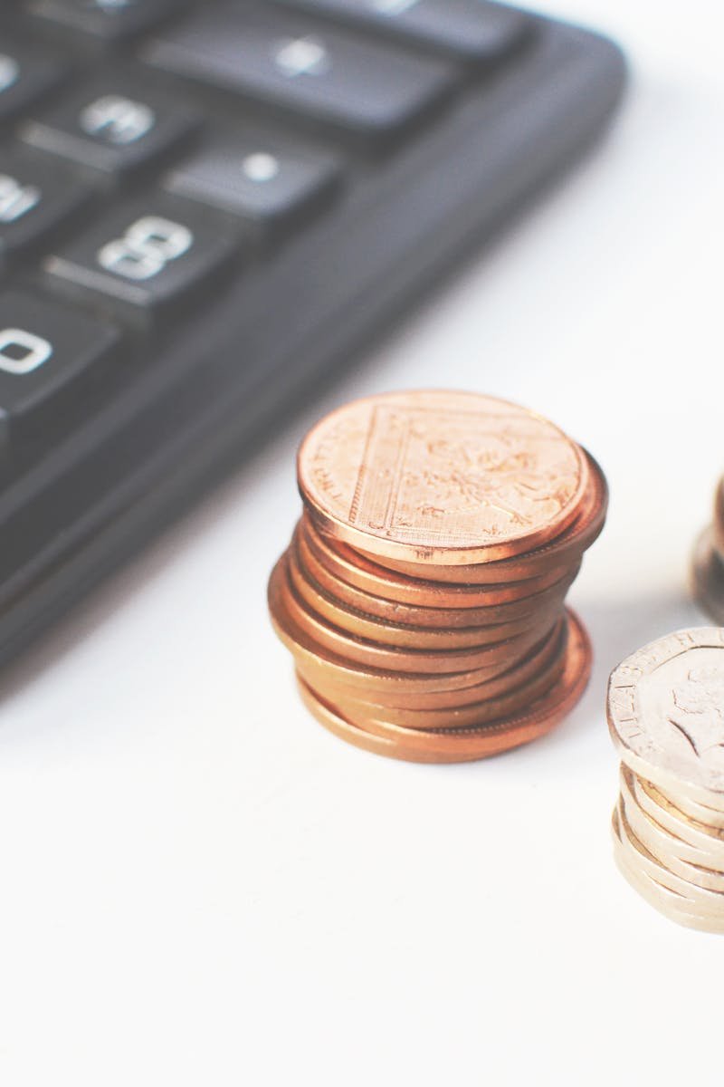 Close-up of stacked coins and a calculator symbolizing financial strategy and budgeting.