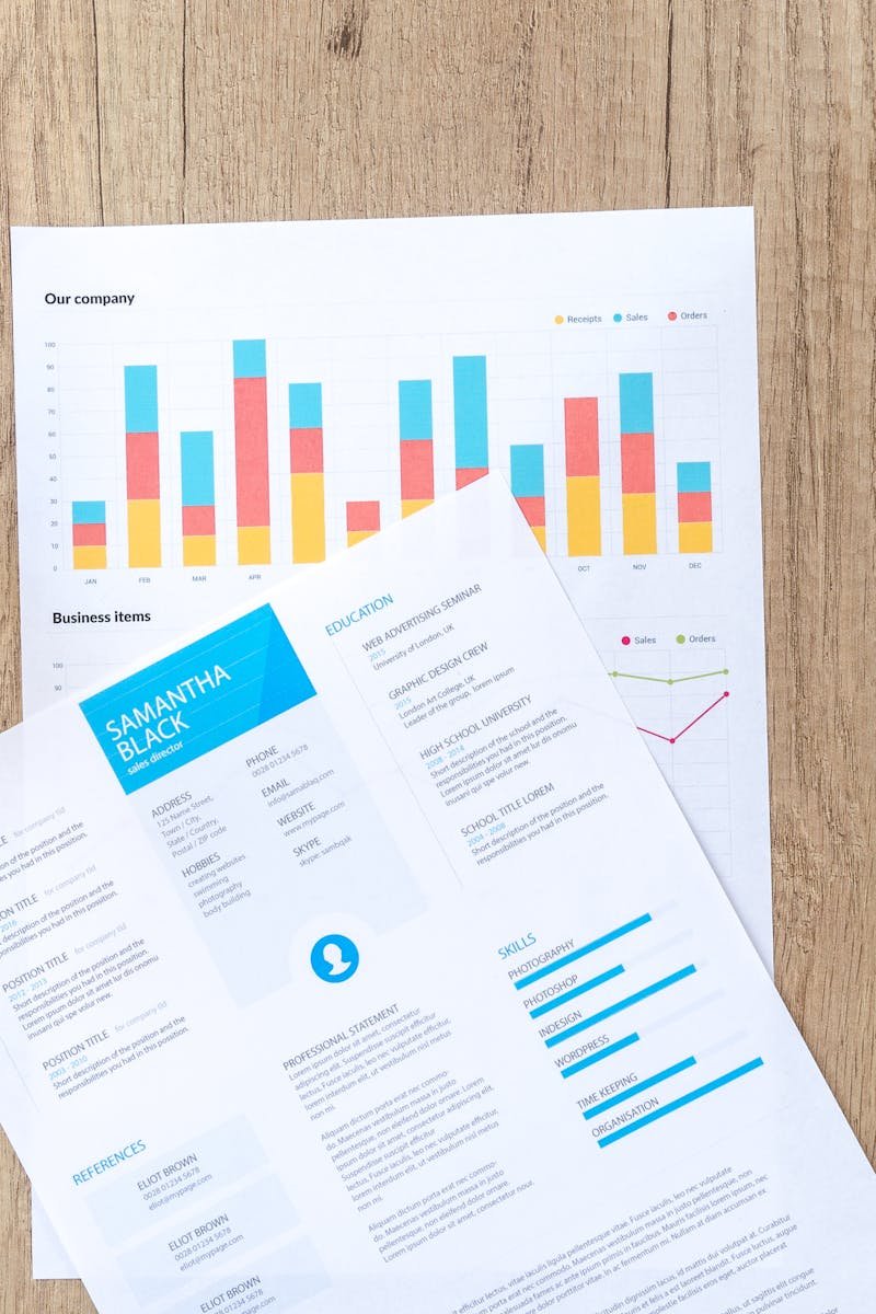Wooden desk with documents, laptop, and coffee cup creating a modern office atmosphere.